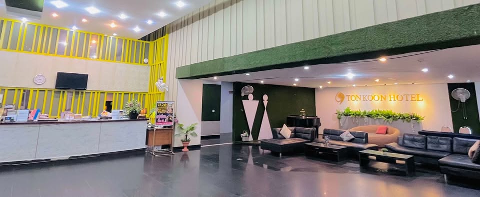 Ton Koon Hotel lobby — reception desk, lounge seating, and gold hotel signage